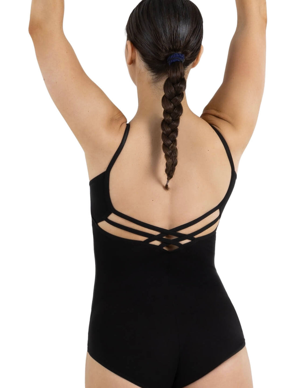 A female dancer lifting her hands over her head with her back toward us, showcasing the strappy back design of a black leotard, single braid in hair.