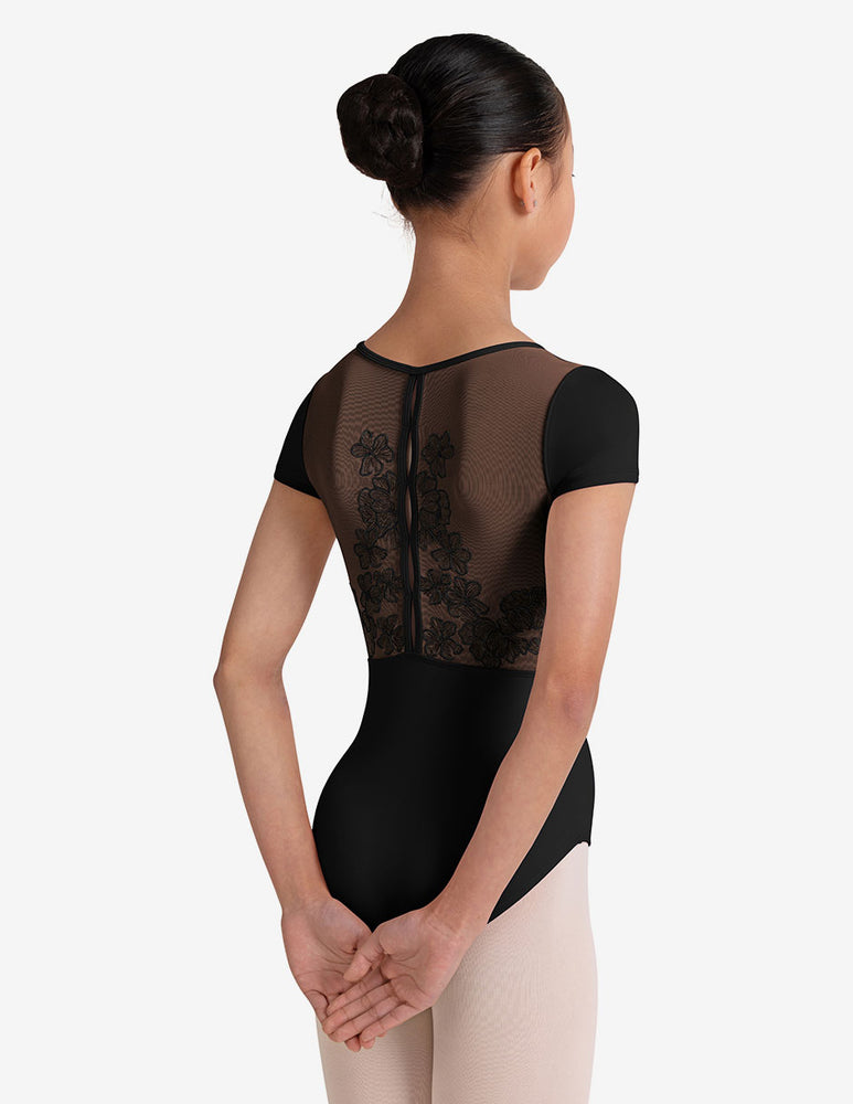 
                      
                        Ballerina with a black bun wearing a black ballet leotard with sheer mesh panels on a white background
                      
                    