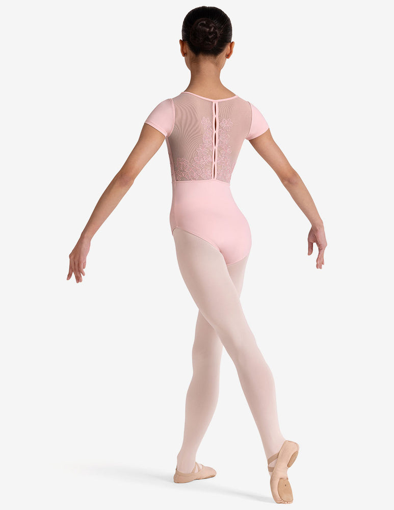 Ballerina in a pink leotard and tights on a white background