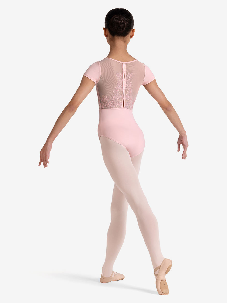Ballerina in a pink leotard and tights on a white background