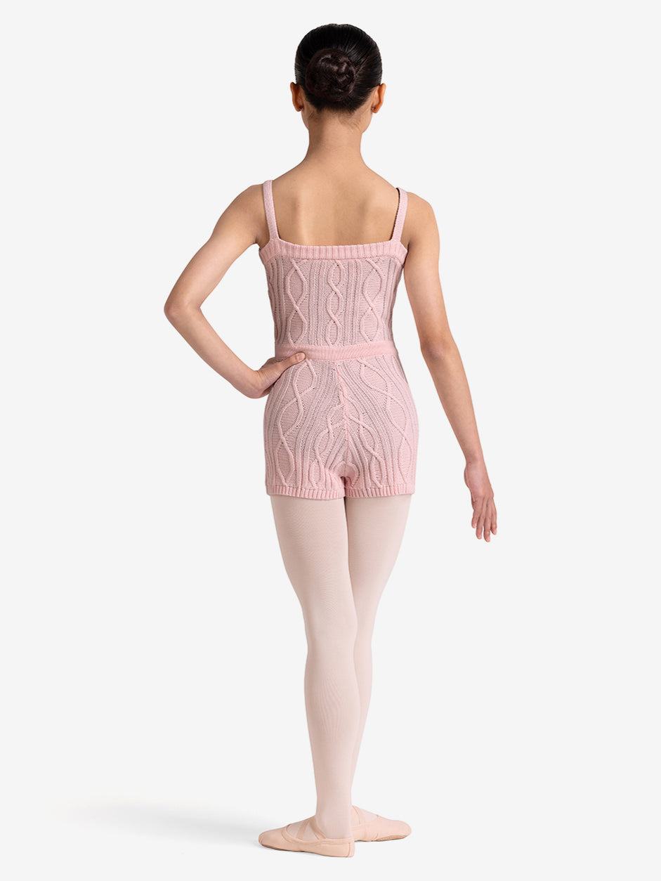 Girl wearing a pink knitted unitard on a white background