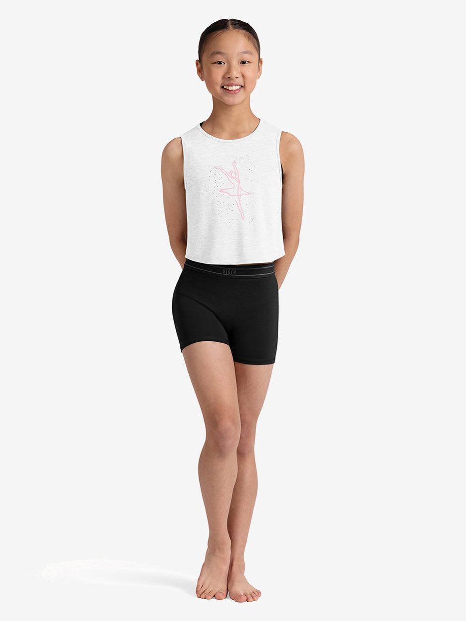 Young girl wearing a white sleeveless top and black shorts on a white background