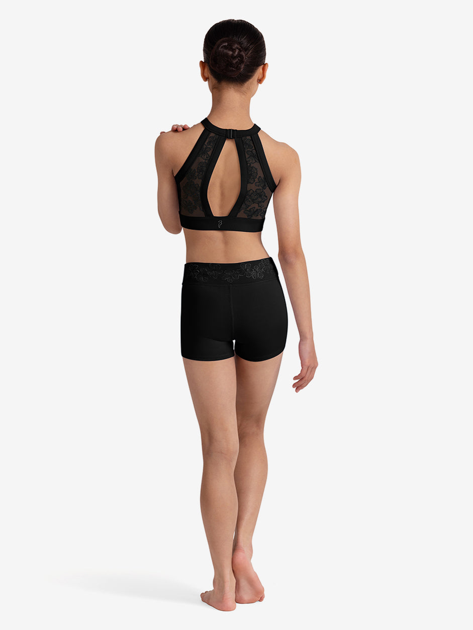 Girl wearing a black lace top and shorts on a white background