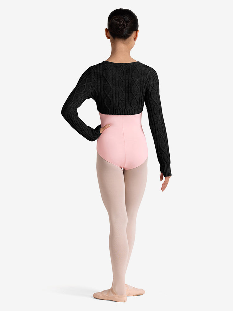 
                      
                        Girl wearing a black long-sleeve top, pink ballet leotard and tights on a white background
                      
                    
