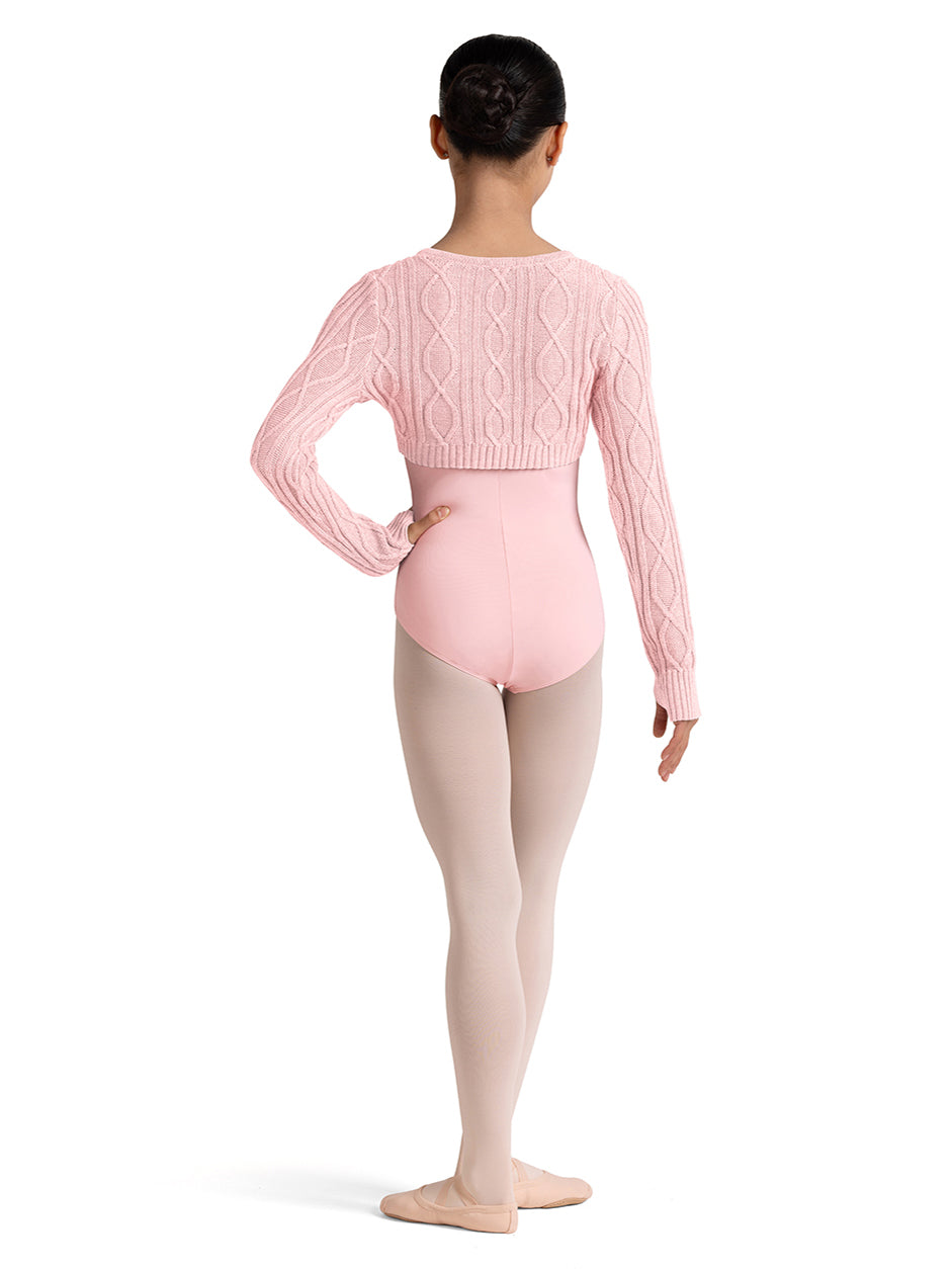 Girl wearing a pink ballet outfit with a sweater and tights on a white background