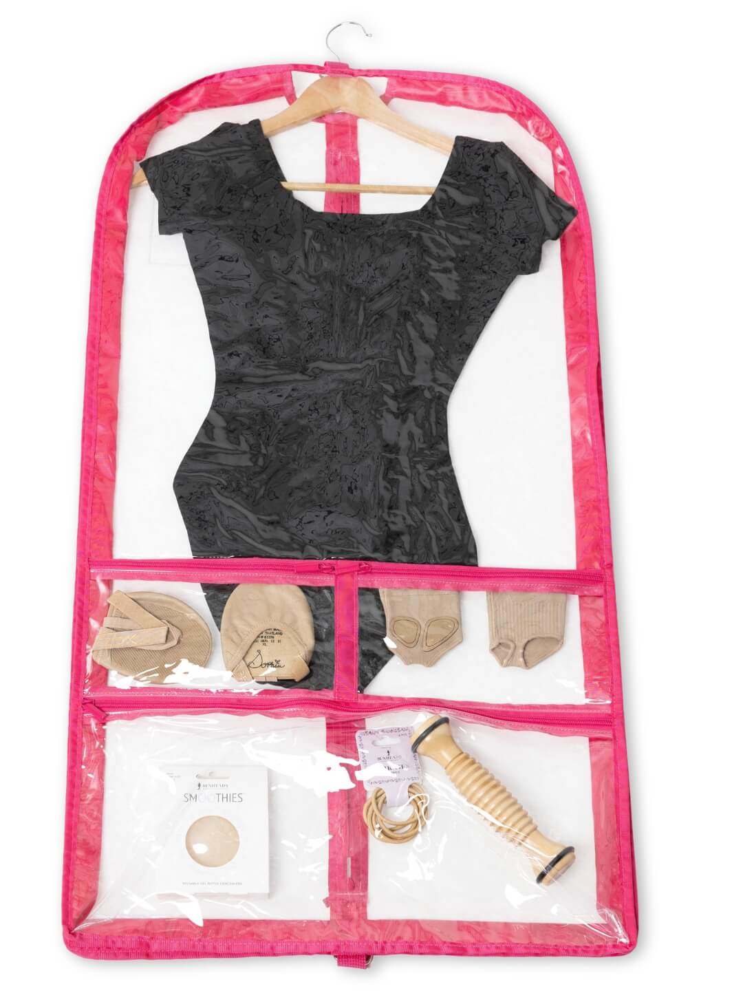 A Clear Capezio Garment Bag with Pink Trim Hanging from a Wooden Handle. The Bag Contains a Leotard and Various Other Dance Accessories.