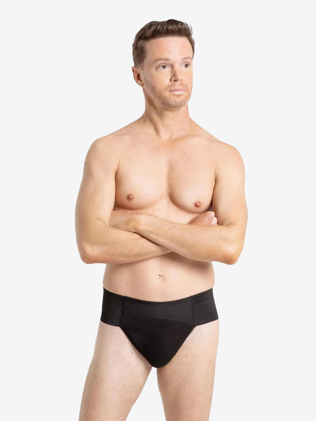 A man with short brown hair is standing against a plain background. He is shirtless and wearing a black-colored compression garment. He has a neutral expression and is looking slightly off to the side.