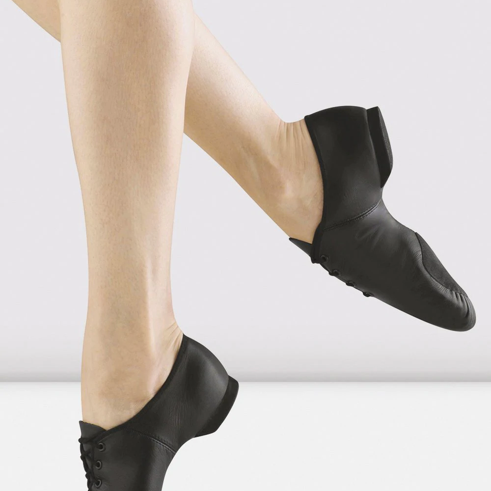 Close-up of a pair of legs wearing black lace-up jazz shoe 