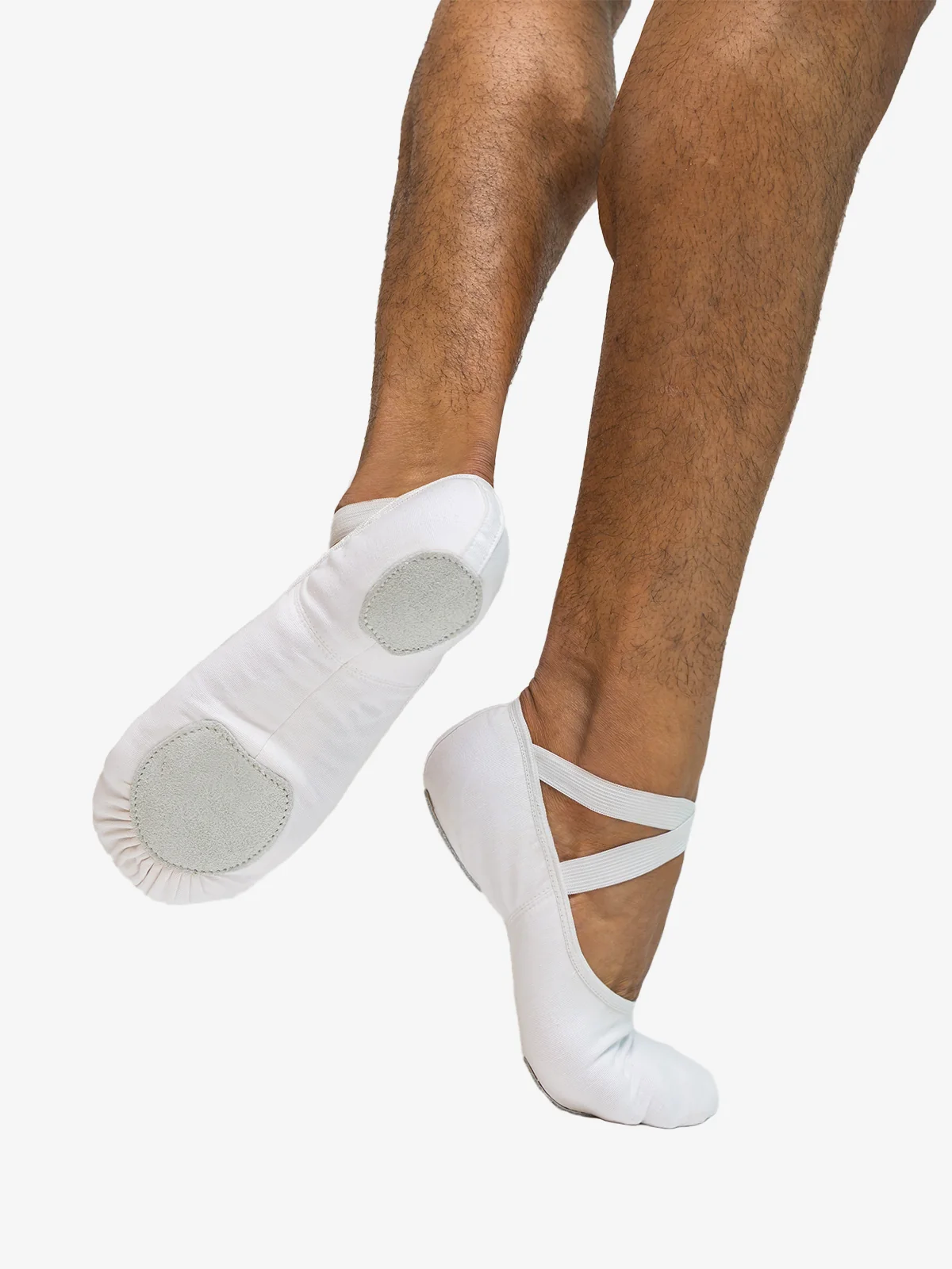 Close-up of a man's legs right foot on releve, back foot lifted showing the bottom of the white ballet shoe