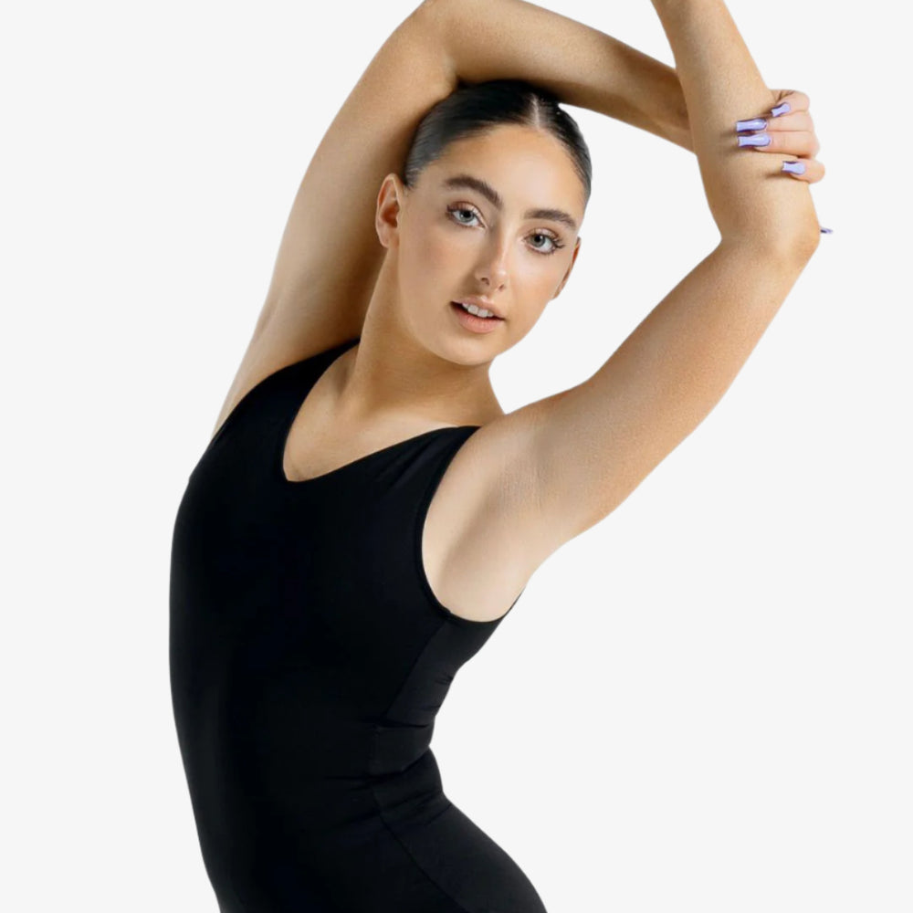 
                      
                        Dancer in a black leotard posing with arms extended on a white background
                      
                    