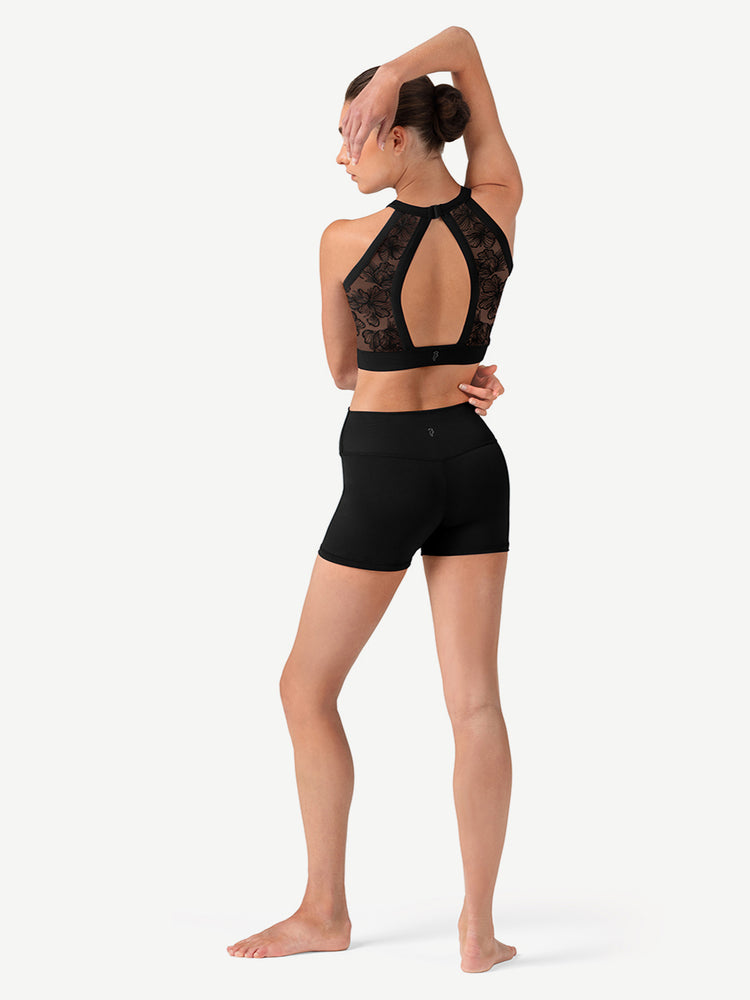 
                      
                        Woman wearing a black lace sports bra and shorts on a white background
                      
                    