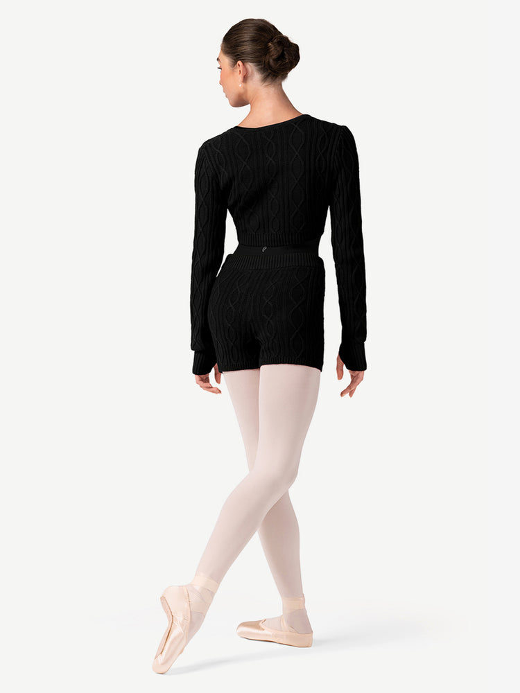 
                      
                        Ballerina in a black long-sleeve top and pink tights on a white background
                      
                    