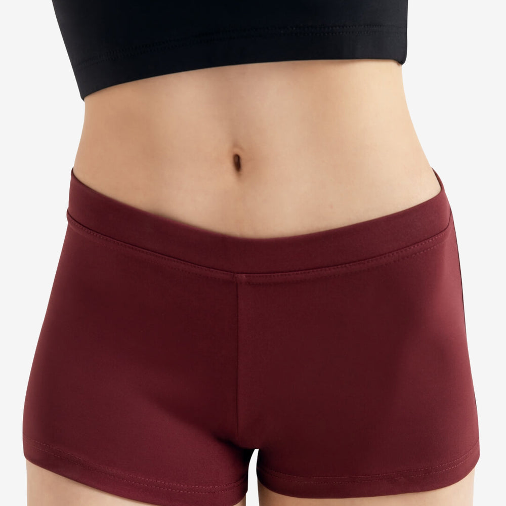 
                      
                        A person wearing a pair of maroon, fitted shorts is shown from the waist to the thighs. The background is plain and neutral.
                      
                    