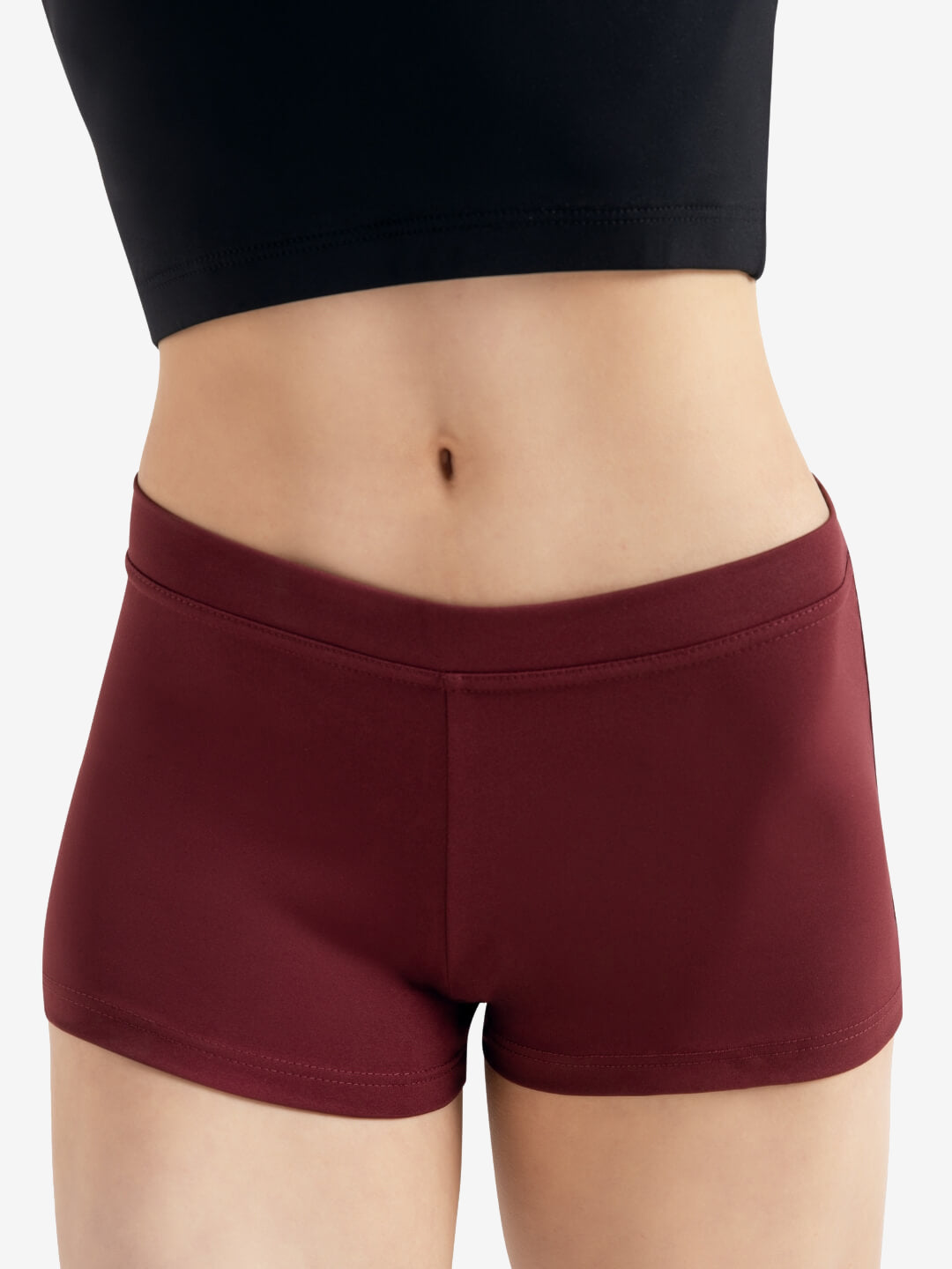 A person wearing a pair of maroon, fitted shorts is shown from the waist to the thighs. The background is plain and neutral.