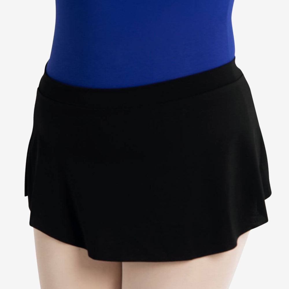 A close-up of a person from the waist to the thigh wearing a royal blue top and black, pull-on, curved skirt, against a plain light grey background.
