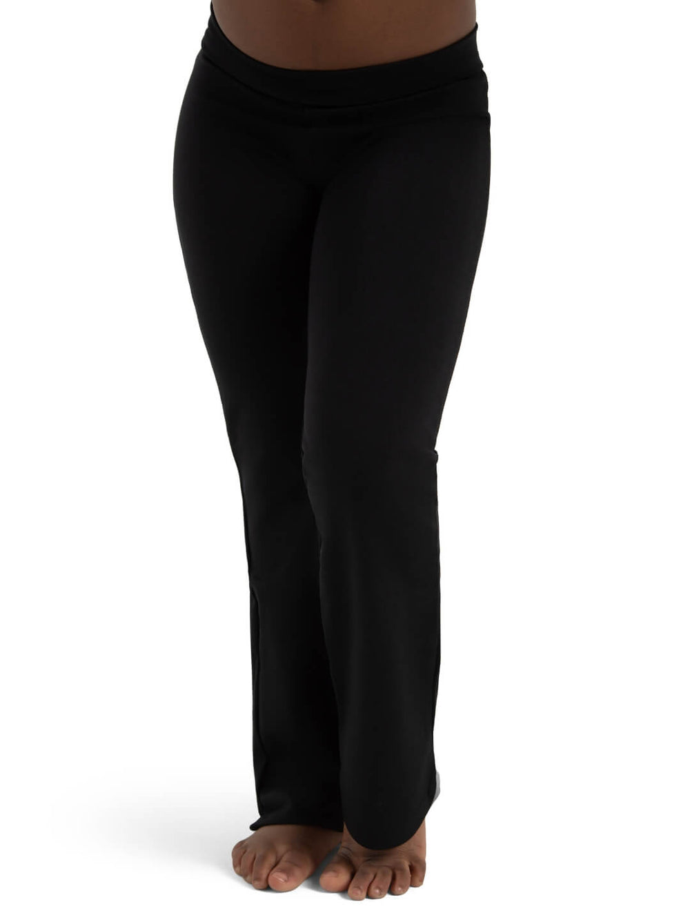 A child standing barefoot, showcasing a pair of black, full-length yoga pants. The pants have a slight flare at the bottom and fit snugly through the hips and thighs. The image focus is on the pants, with the person's upper body out of frame.
