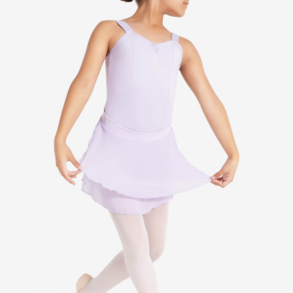 
                      
                        A young girl with her hair pulled back into a bun looks to the side. She wears a lavender leotard and lavender skirt that she pulls out slightly to show the layers. She stands on one leg, the back leg bent behind her. Plain light grey background.
                      
                    