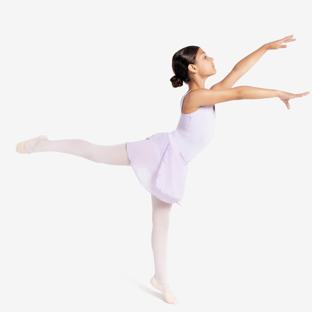 
                      
                        A young ballerina stands in an arabesque pose in a minimalistic setting. She wears a light purple leotard with an attached skirt, white tights, and pink ballet shoes. Her hair is pulled back into a neat bun, and her arms are gracefully extended.
                      
                    