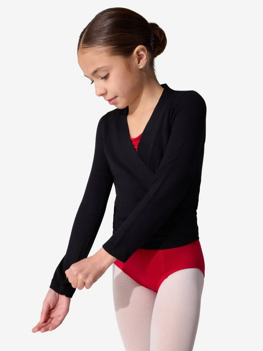 Young girl wearing a black long-sleeve sweater and red leotard on a white background