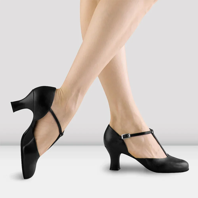 Black character shoes worn by a person on a light gray background