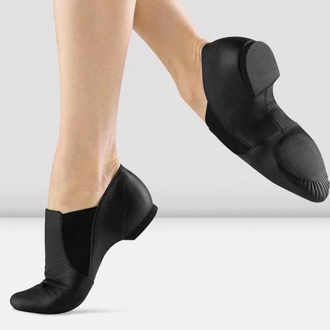 Black jazz shoes worn by a person on a light gray background