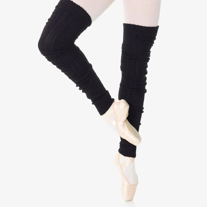 Ballerina wearing black leg warmers and pointe shoes on a white background