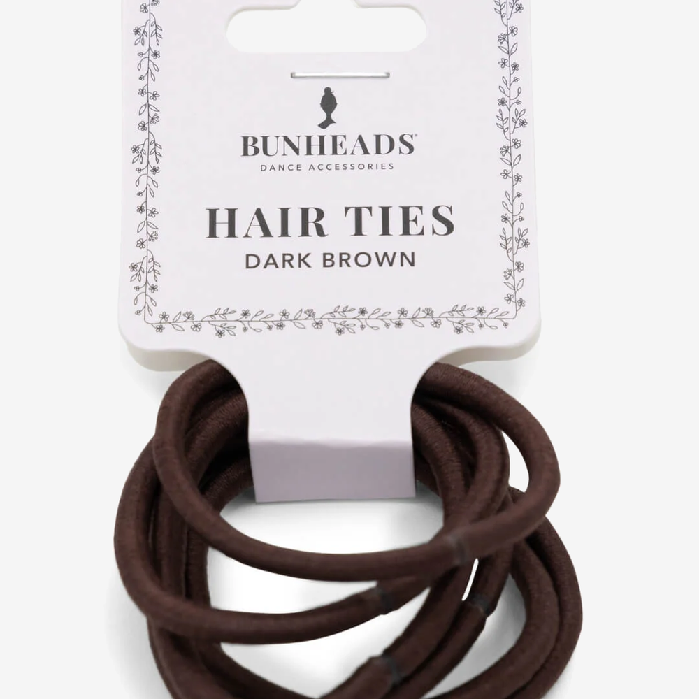 
                      
                        A single package of six dark brown hair ties against a plain background.
                      
                    