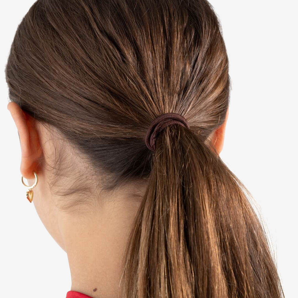 
                      
                        The back of a person's head, brunette hair pulled into a ponytail with a brown hair matching hair tie. She accessorizes with small dangling earrings.
                      
                    
