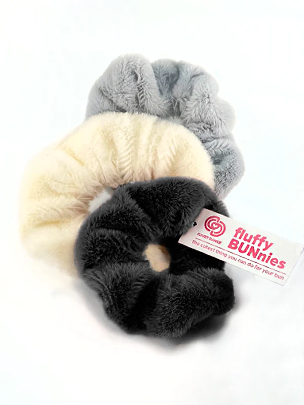 
                      
                        A set of three neutral colored fluffy, soft scrunchies with a white tag with pink text that read fluffy BUNnies.
                      
                    