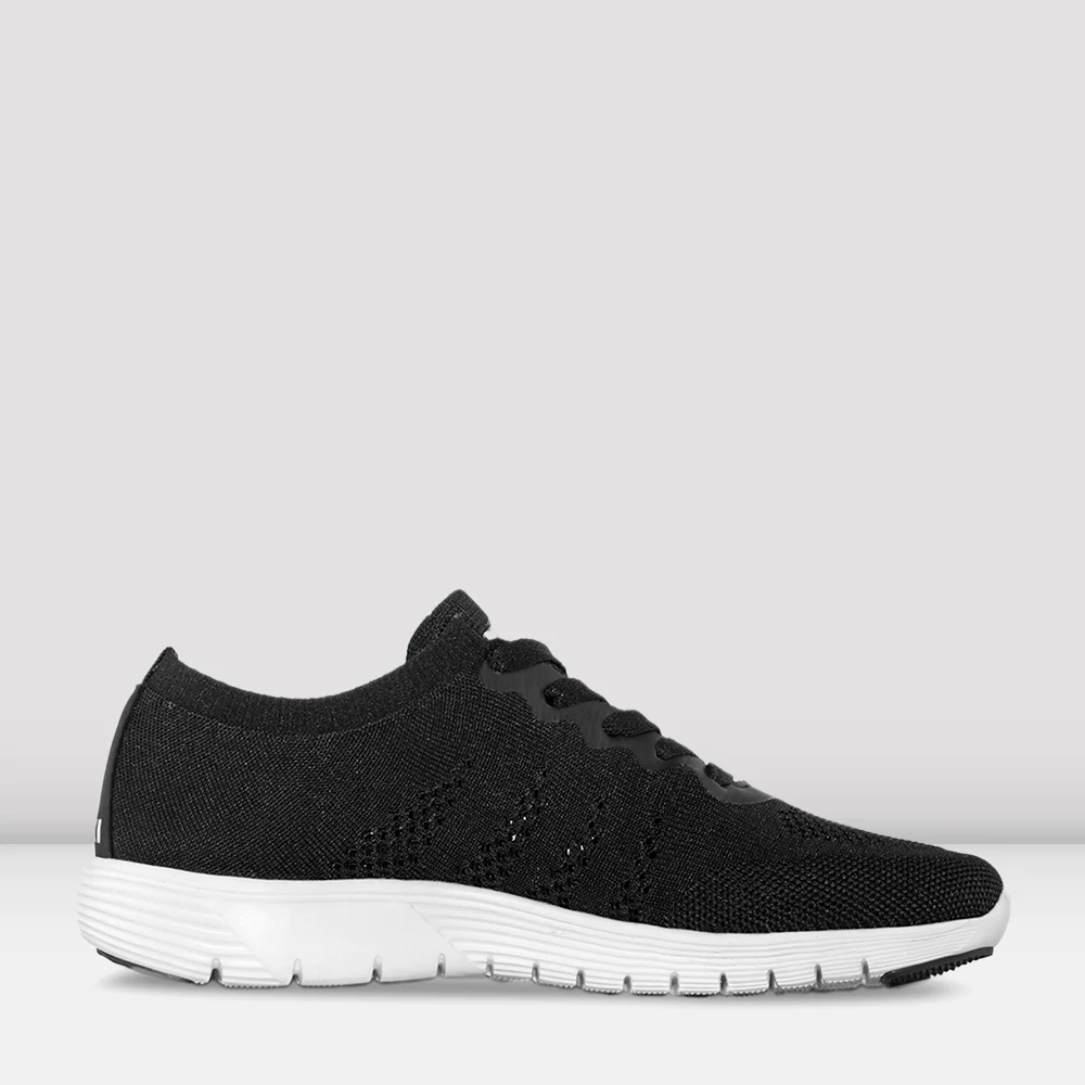 An image of a single shoe facing the right. The sneaker has a black knitted material upper and a white sole. Plain, light grey background.