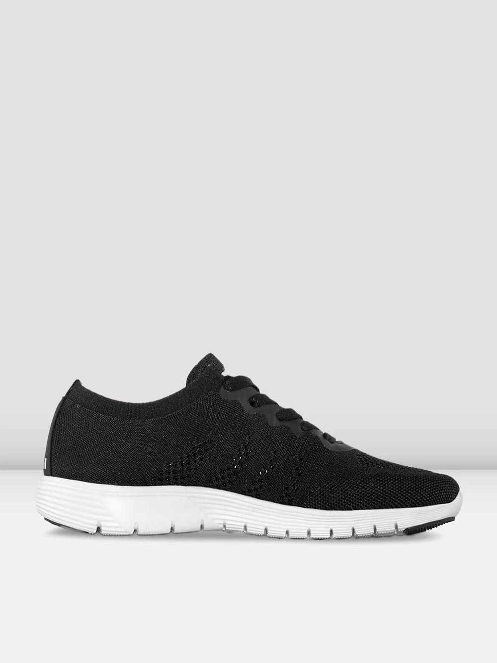 An image of a single shoe facing the right. The sneaker has a black knitted material upper and a white sole. Plain, light grey background.