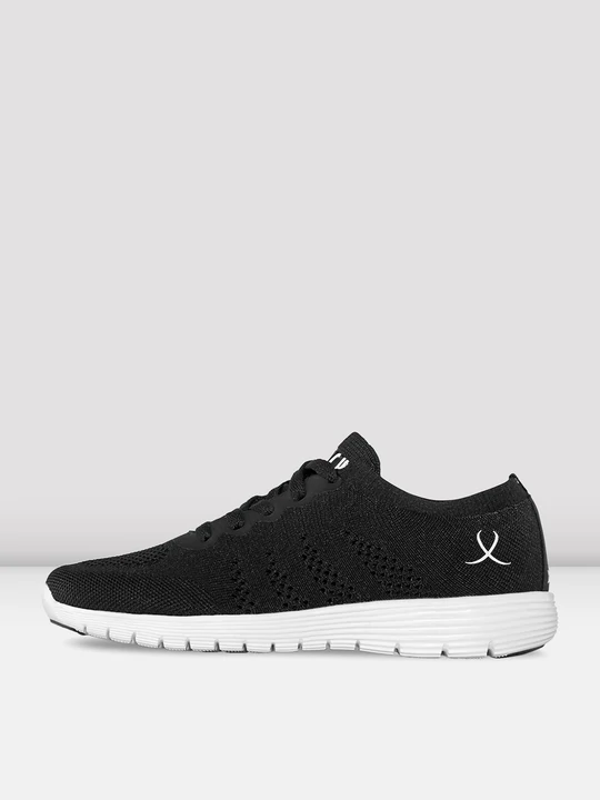 Image of a single sneaker facing the left, featuring a black knitted material upper, a small white logo toward the back heel, and a white sole, all against a light grey background.