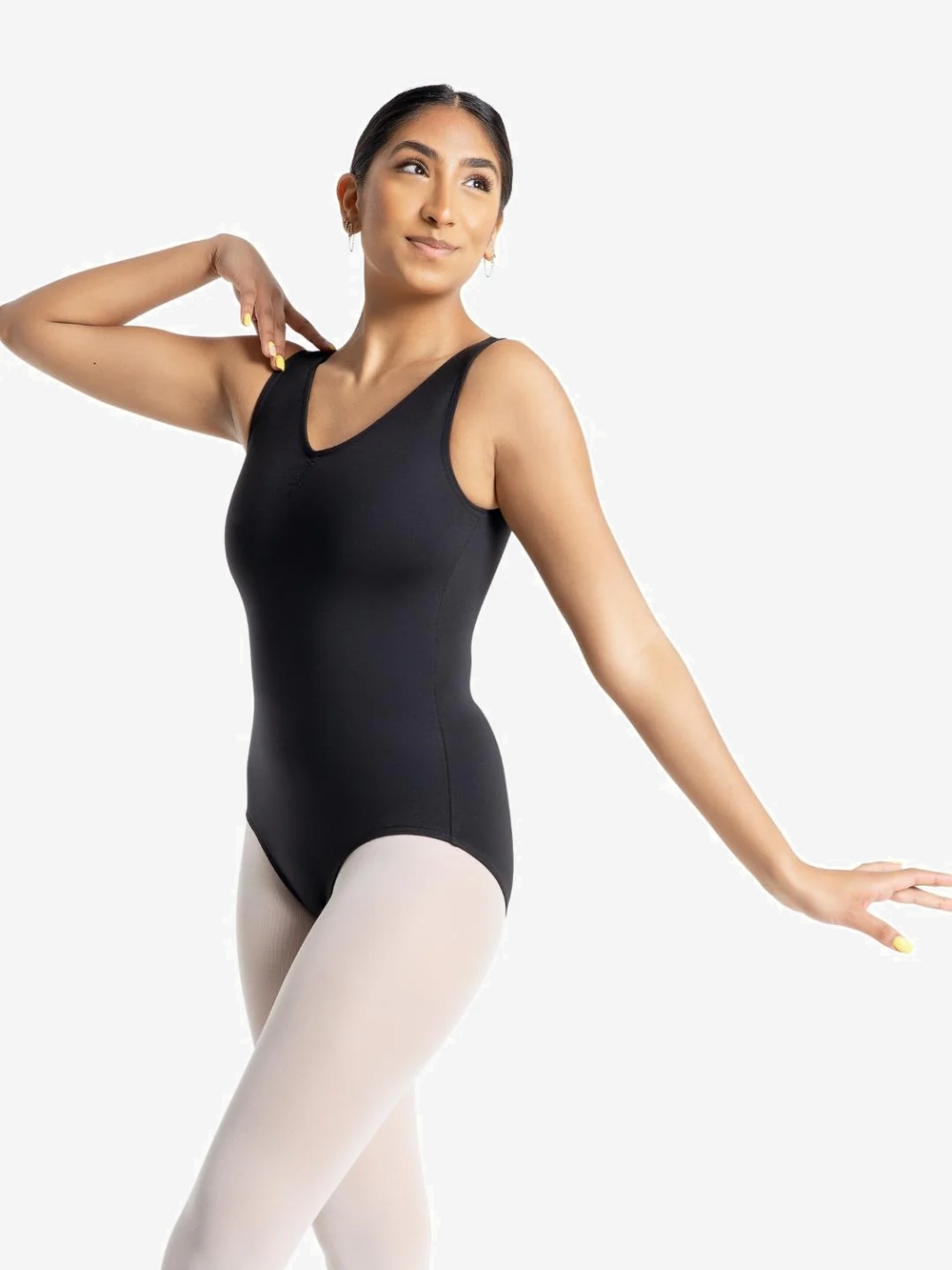 Dancer in a black leotard and pink tights on a white background