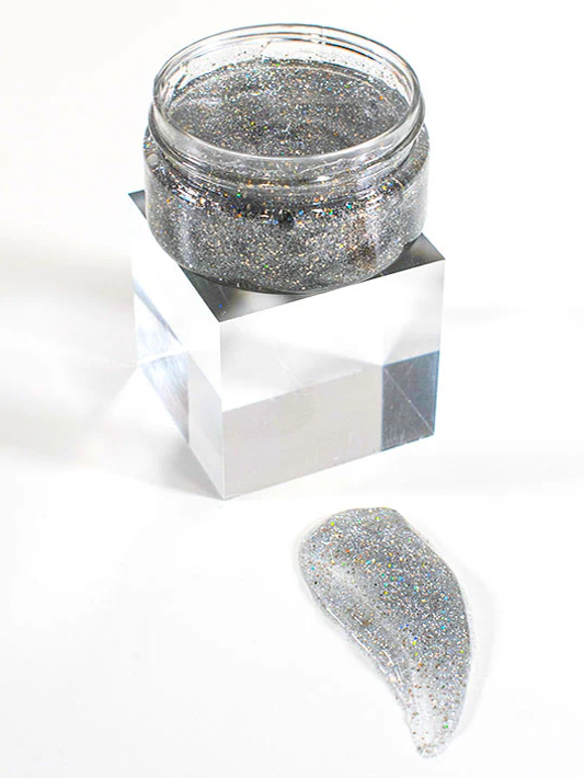 
                      
                        An open jar of silver sparkle gel sits on display with a smear of it in front for showcasing
                      
                    