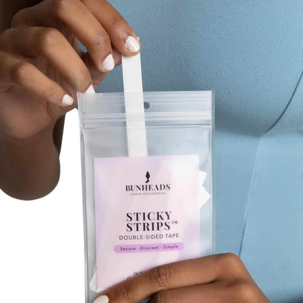 Person holding a package of Bunheads Sticky Strips with a clear background