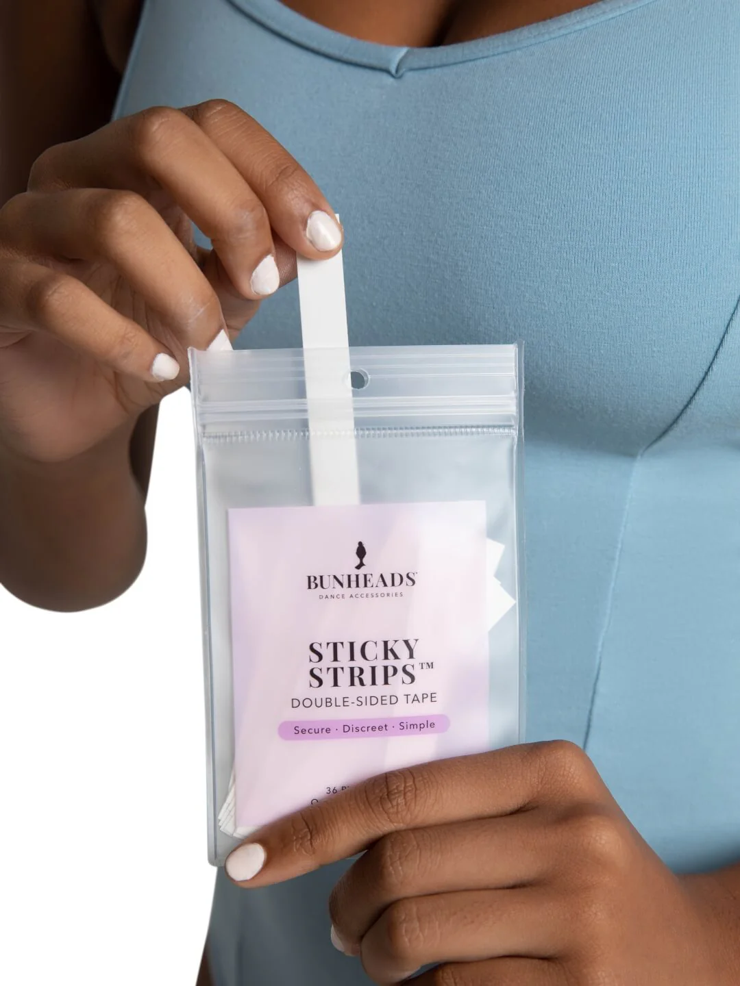 Person holding a package of Bunheads Sticky Strips with a clear background