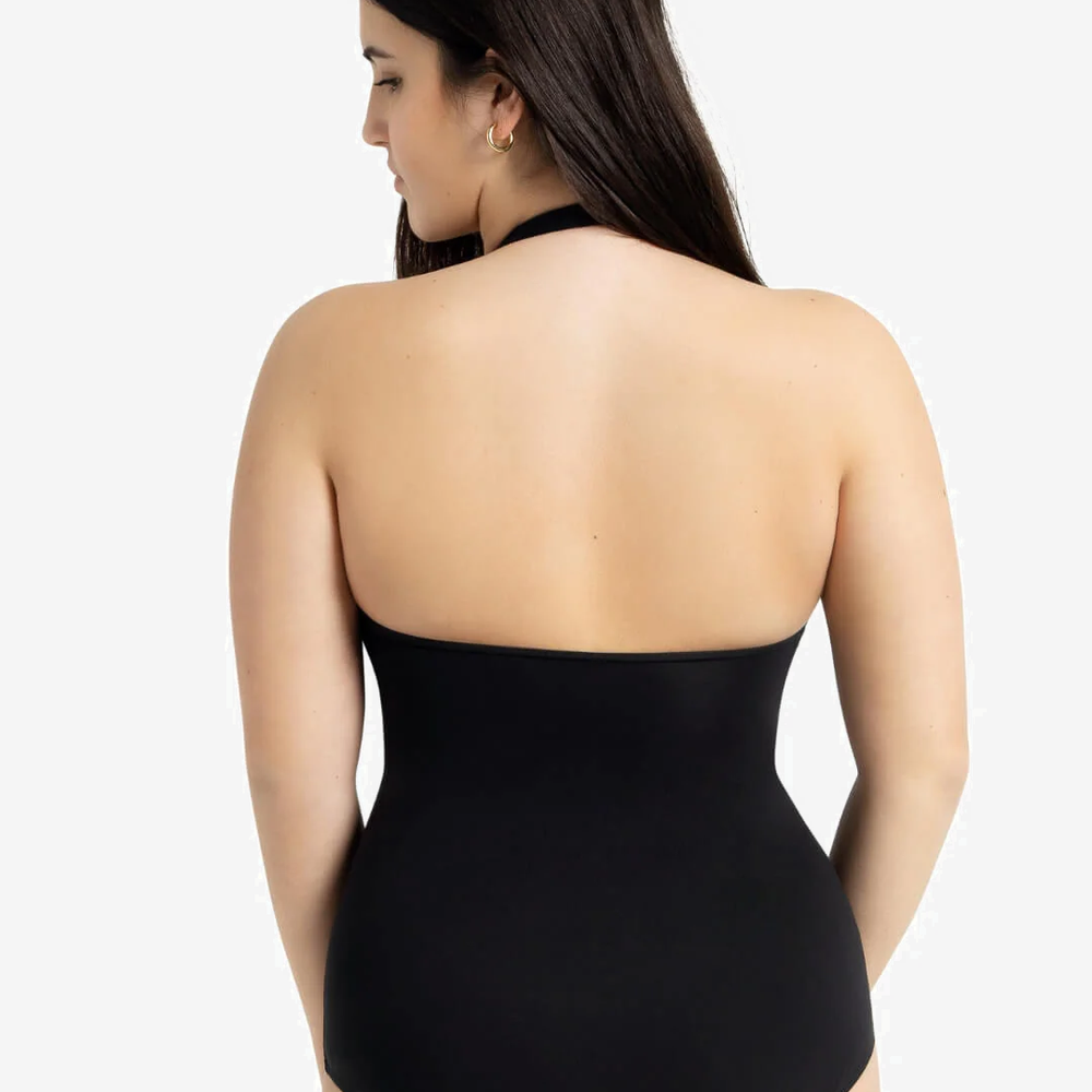 
                      
                        Woman wearing a halter neck black leotard n a light grey background
                      
                    
